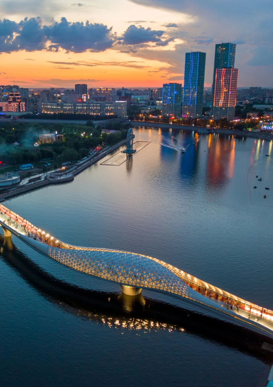 The pedestrian bridge over the Esil and Astana at sunset