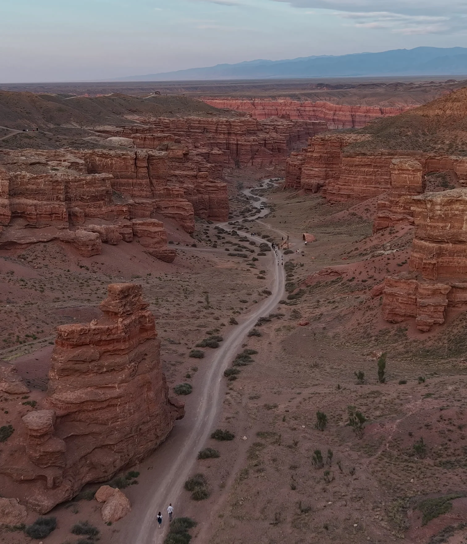 Charyn Canyon from above at dusk: a trail between red rock towers