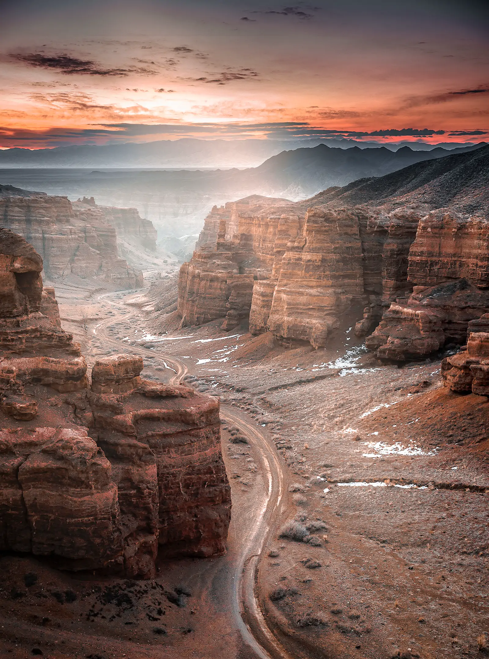 Charyn Canyon at sunset, with a road winding between red cliffs